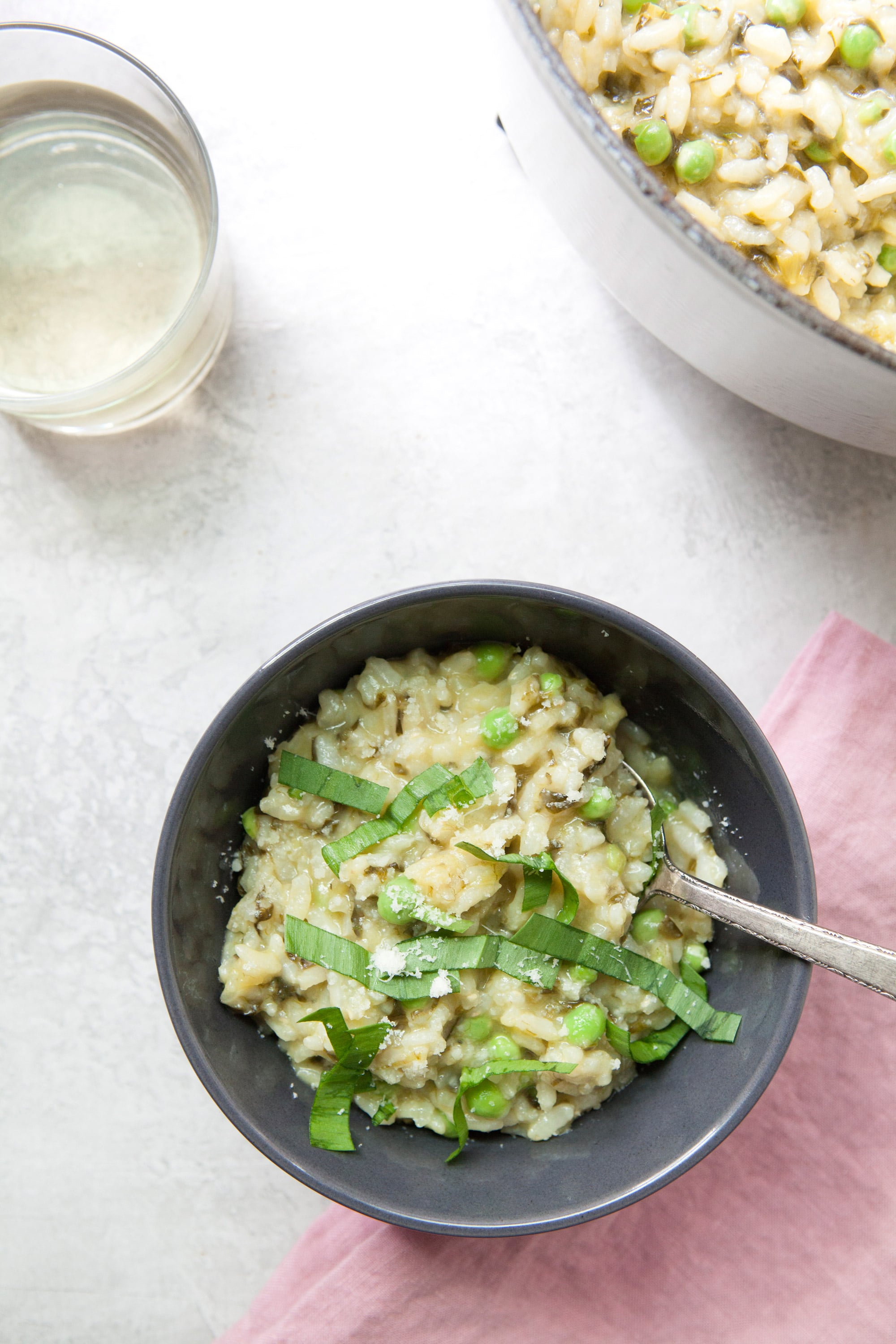 Spring Ramp and Pea Risotto in dark bowl on table.