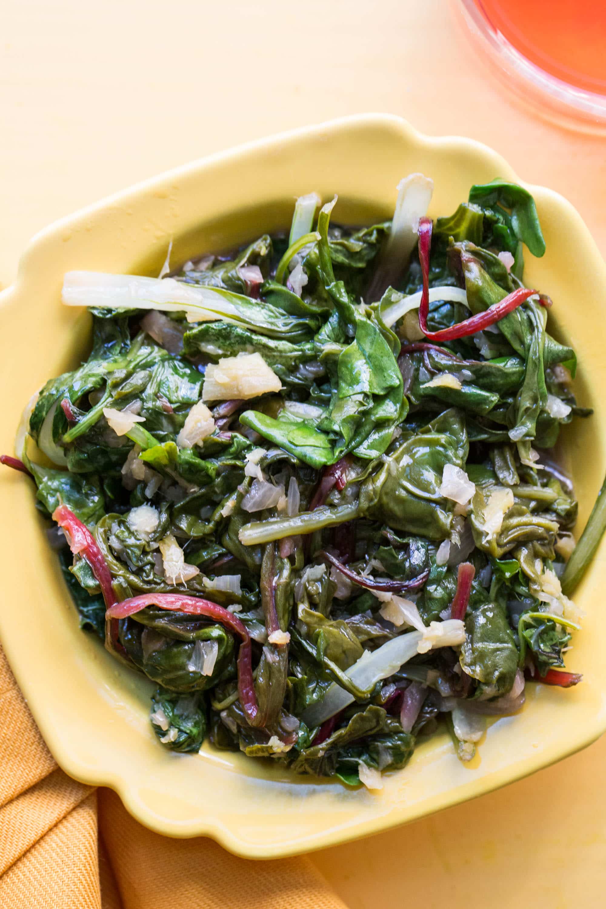 Spicy Asian greens in yellow bowl on table.