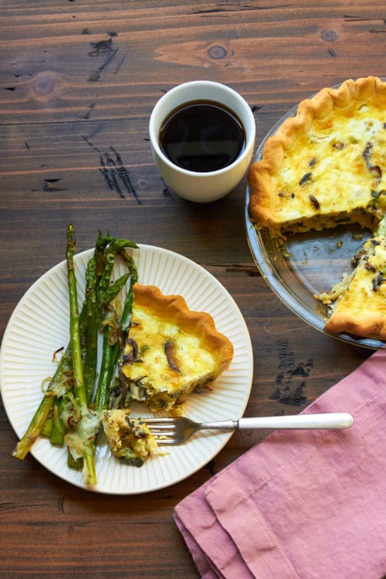 Fork taking a piece of Leek, Mushroom and Goat Cheese Quiche.