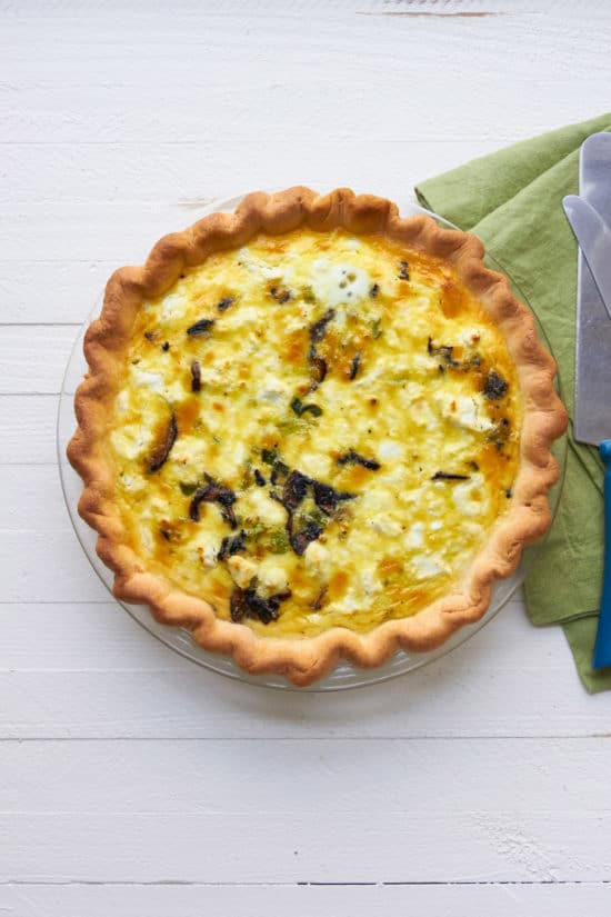 Leek, Mushroom and Goat Cheese Quiche on a white table.