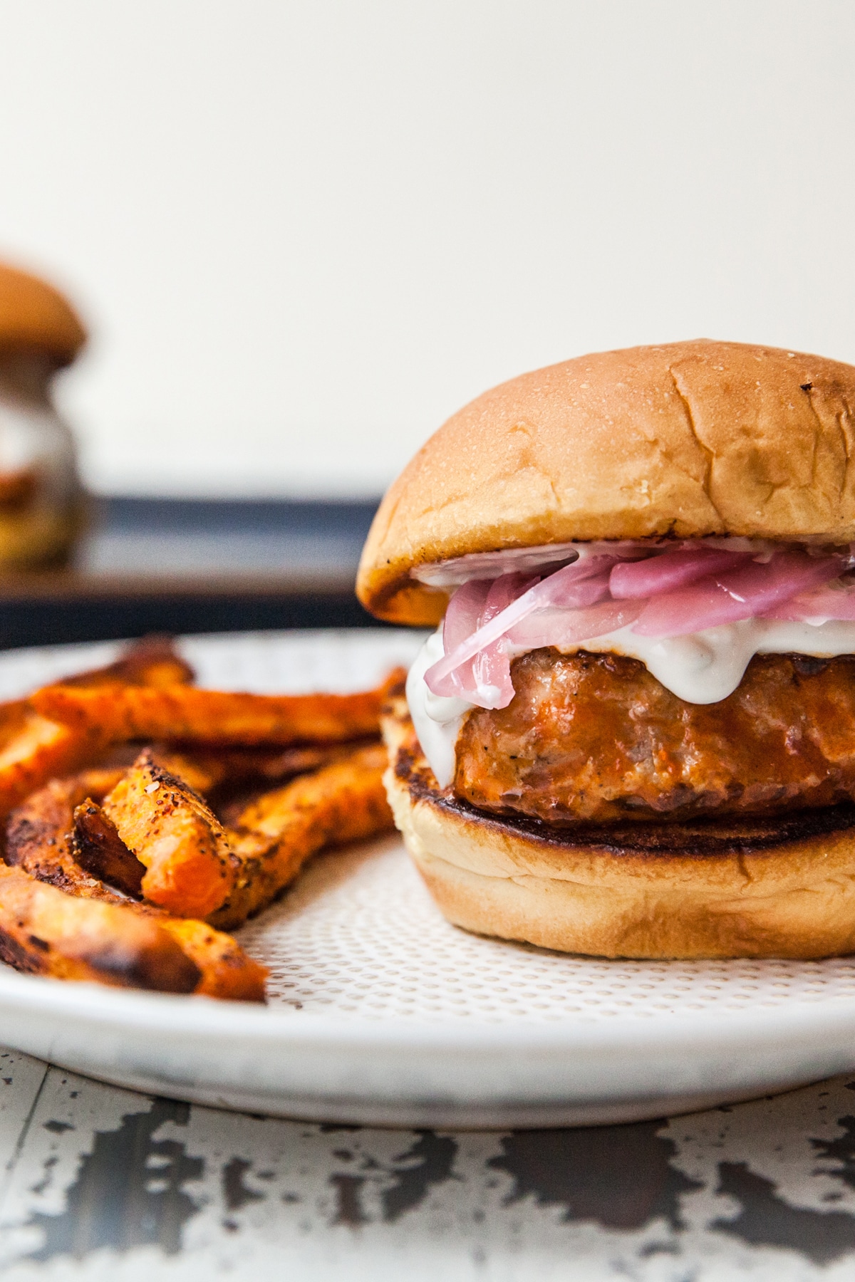 Buffalo Turkey Burger Slider with sweet potato fried on a plate.