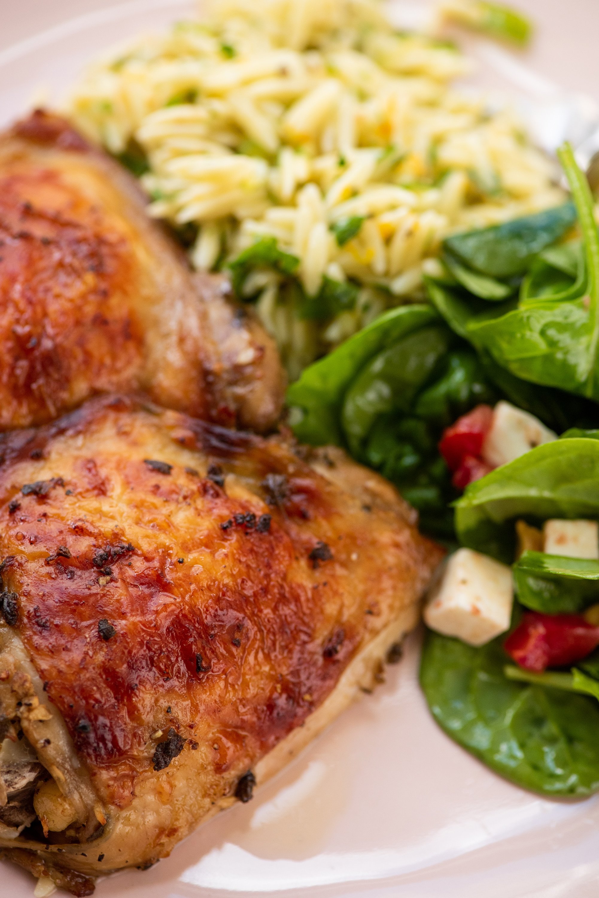 Roasted chicken thighs on a plate with salad.