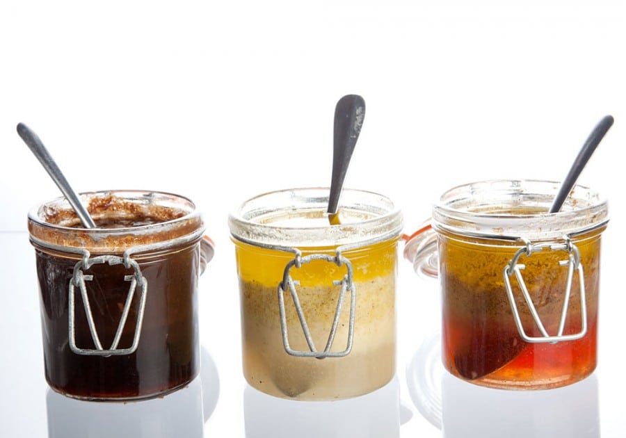 Jars of three different types of vinaigrettes.