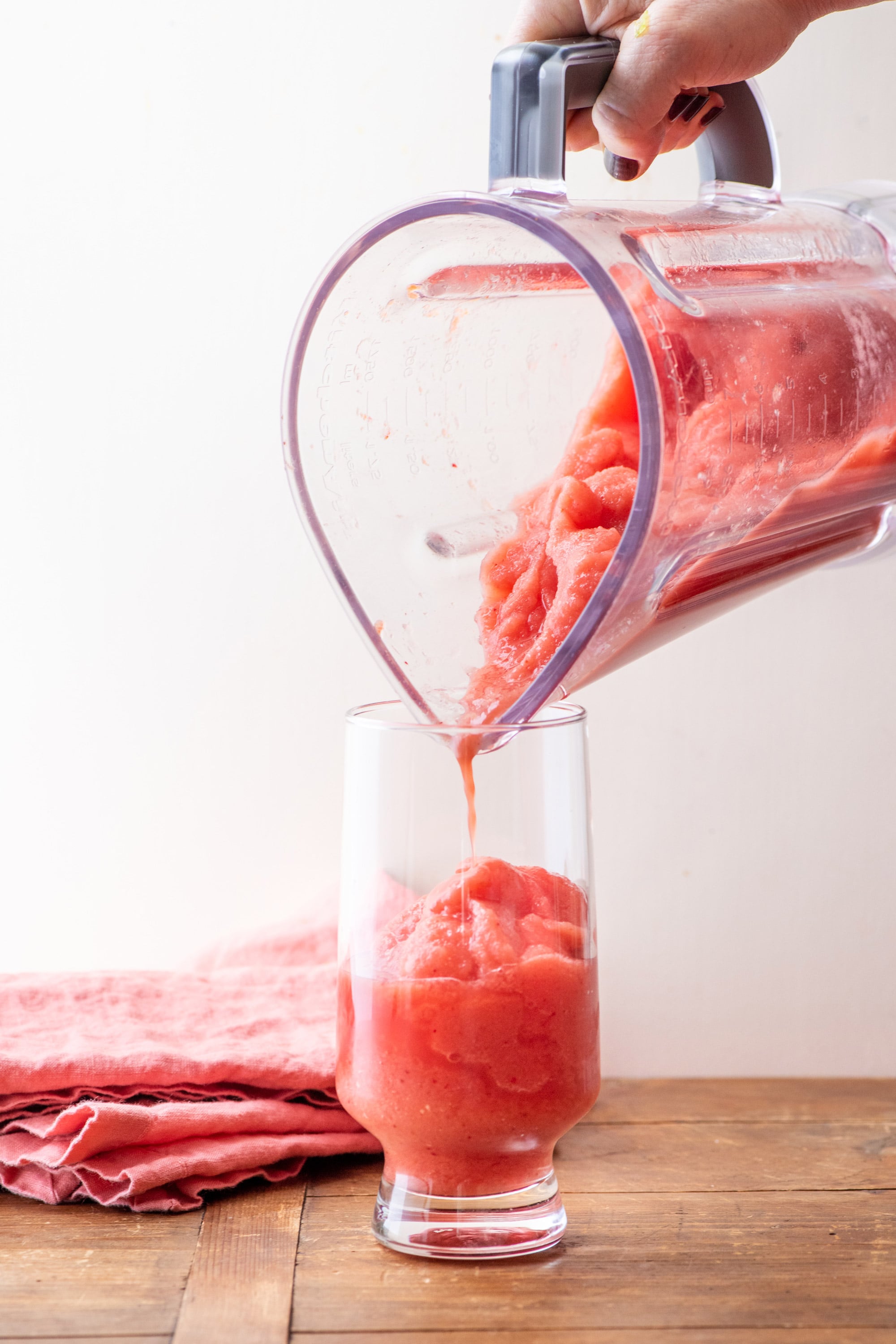 Blender pouring Watermelon Strawberry Smoothie into a glass.