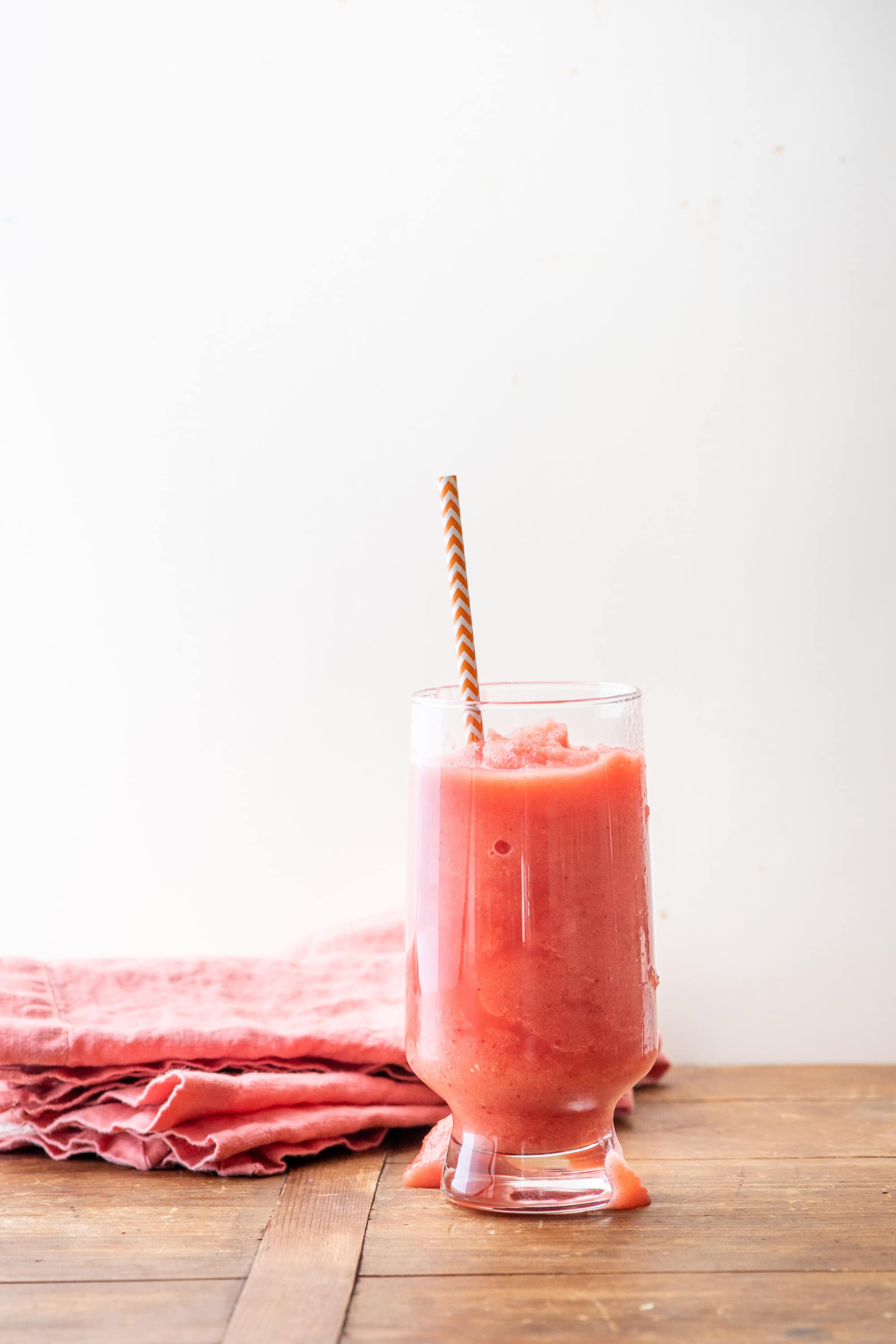 Glass of Watermelon Strawberry Smoothie with a colorful straw.
