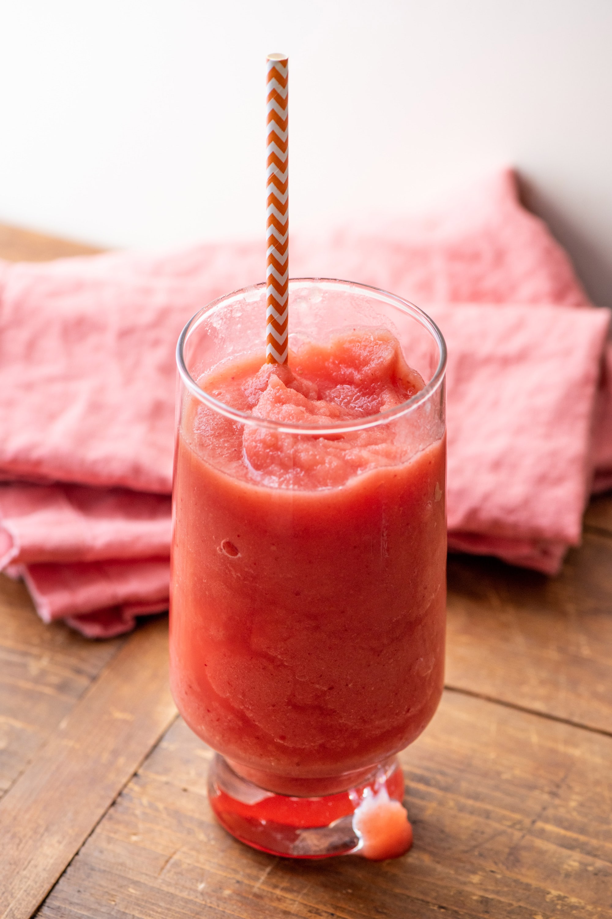 Colorful straw in a tall glass of Watermelon Strawberry Smoothie.