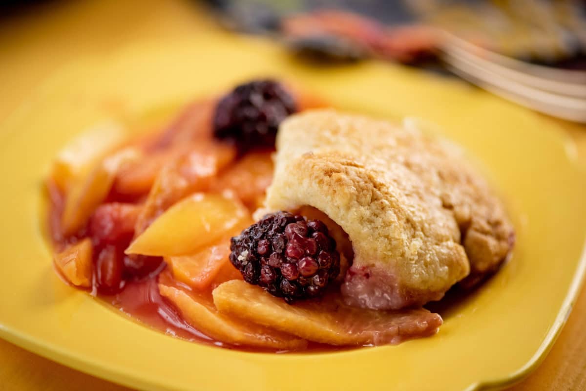 Sour Cream Biscuit Peach and Berry Cobbler on a yellow plate.