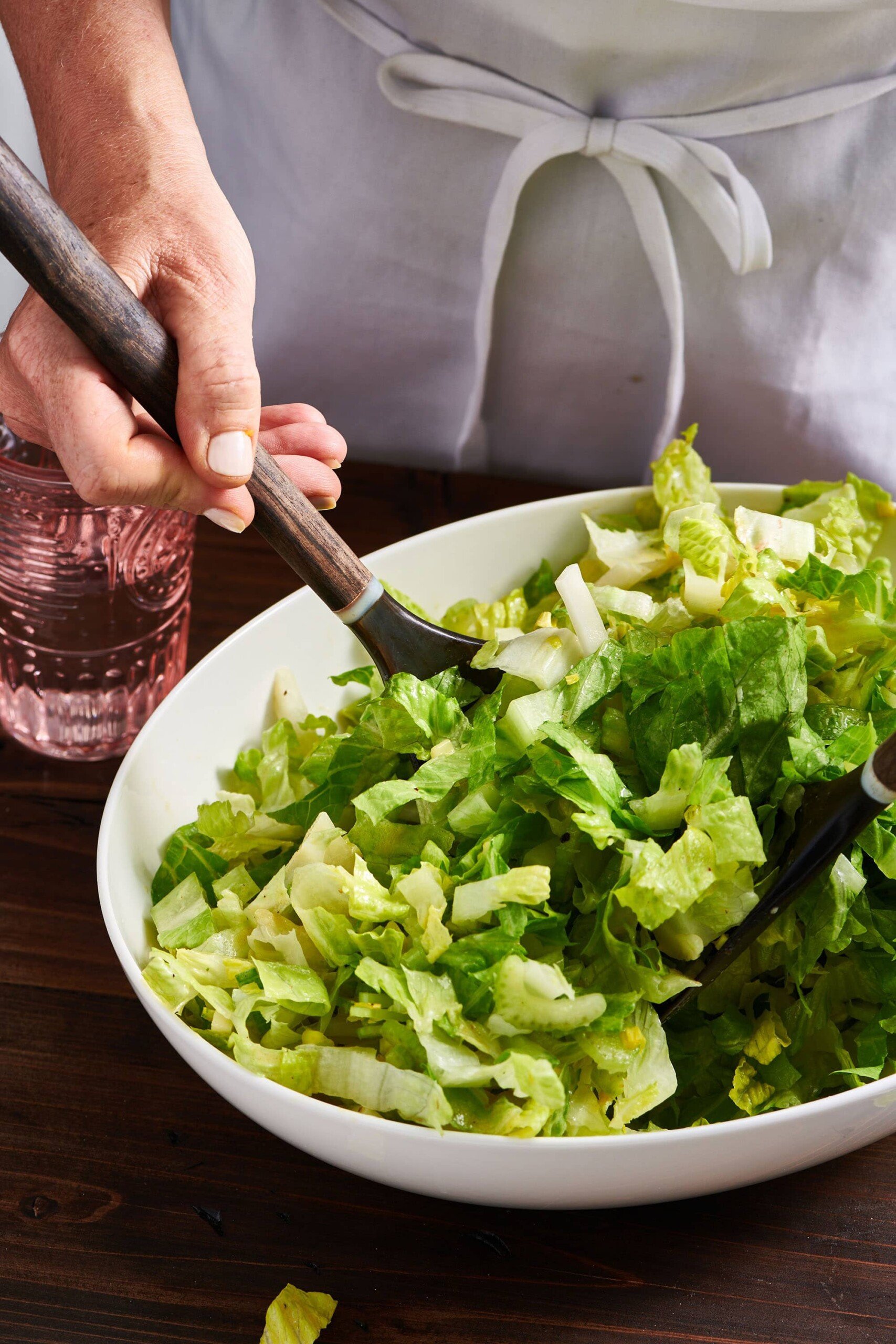 Tossing Crunchy Mixed Green Salad in bowl.