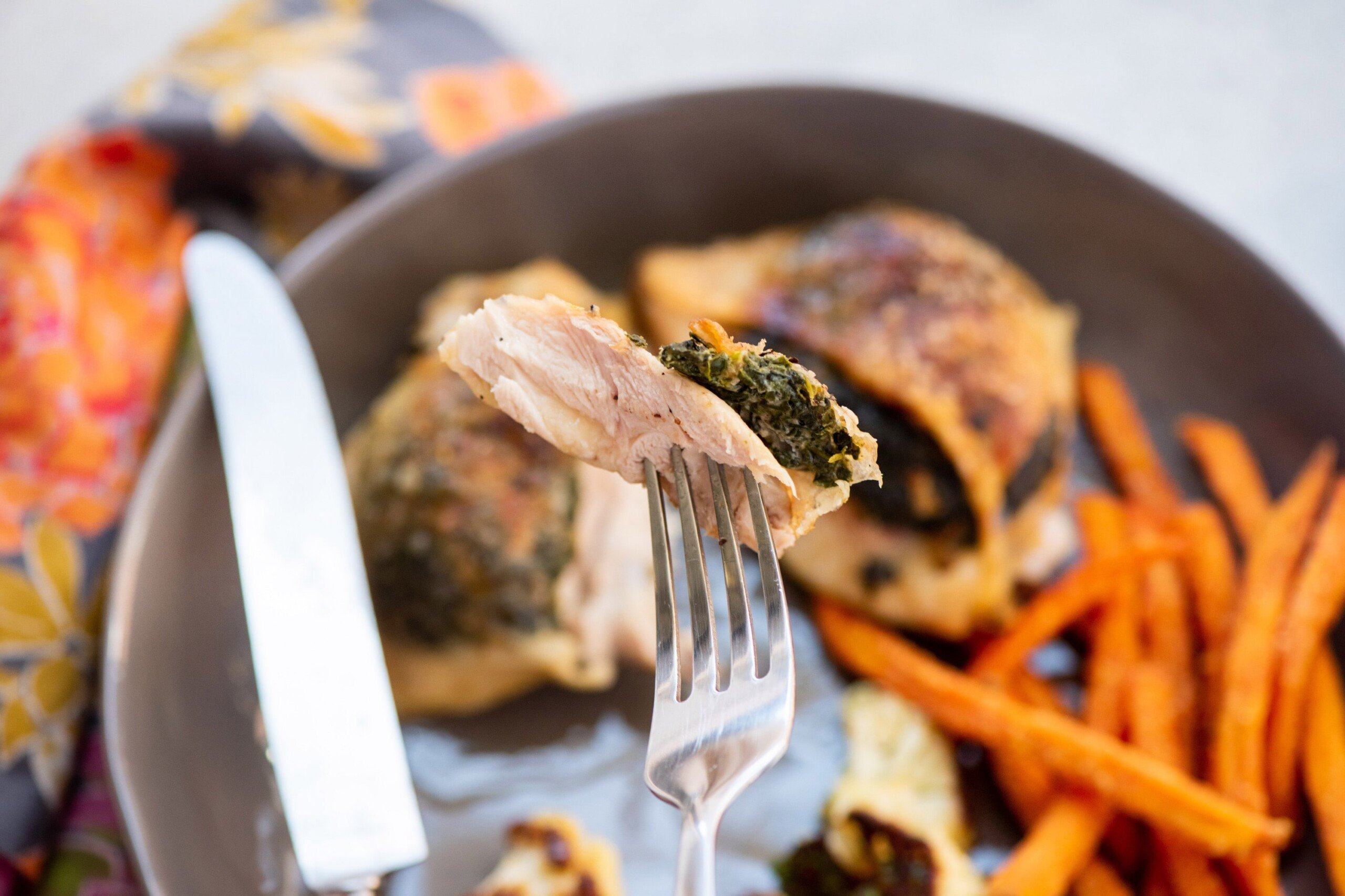 Fork with a piece of Creamed Spinach Stuffed Chicken Thigh.