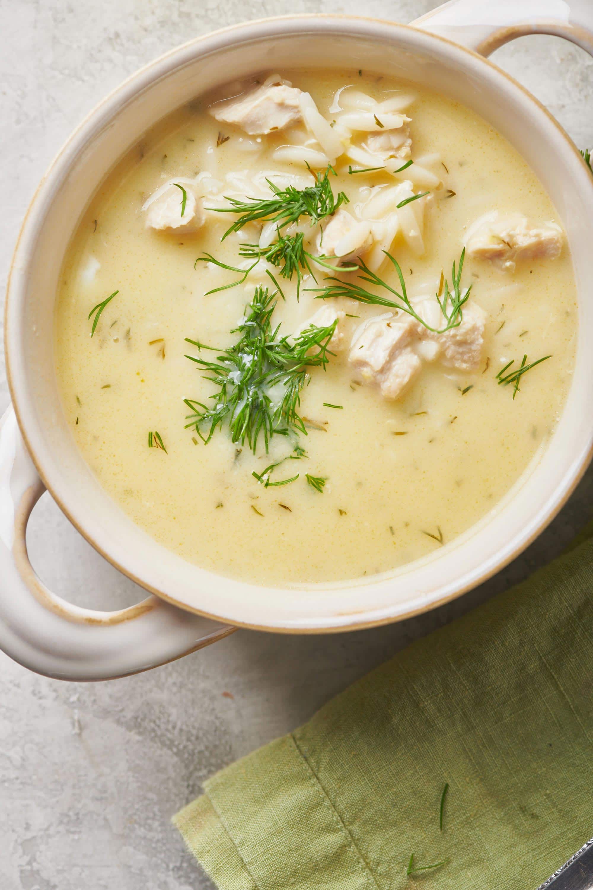 Bowl of Avgolemono Soup topped with dill.