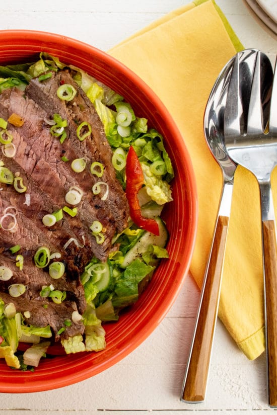 Red bowl of Smoky Sweet Thai Grilled Flank Steak Salad.