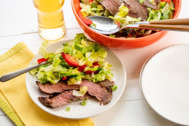 Plate and bowl of Smoky Sweet Thai Grilled Flank Steak Salad.