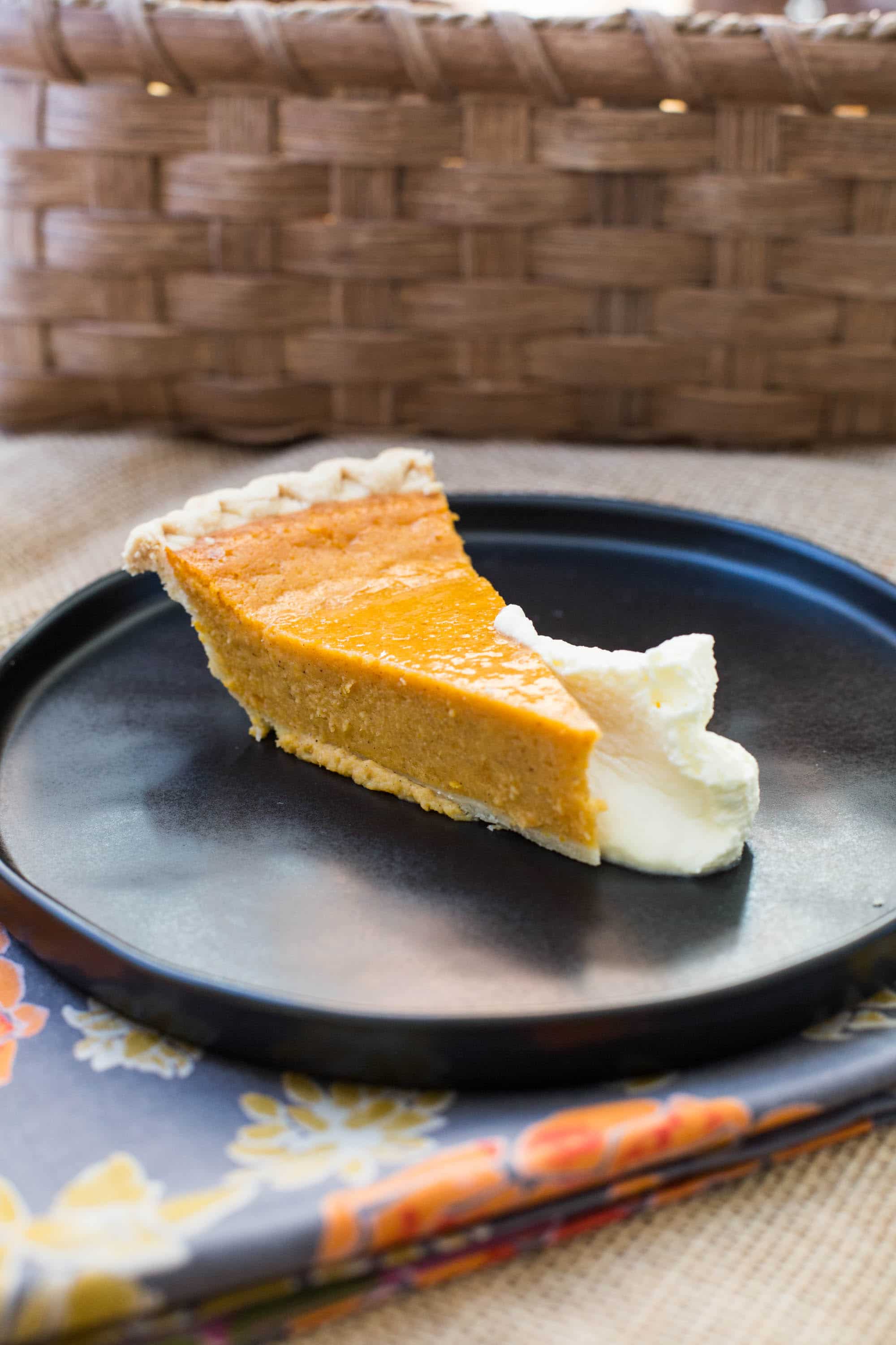 Slice of Sweet Potato Pie on a plate with whipped cream.