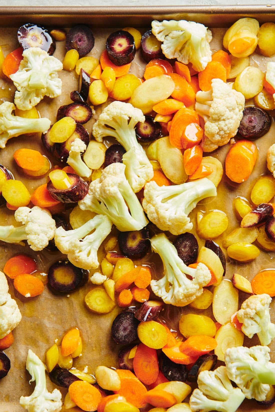 Cauliflower and Carrots on a lined baking sheet.