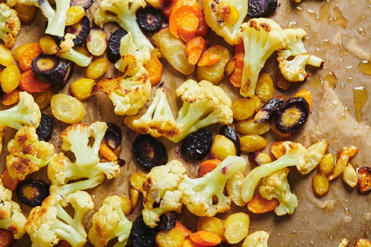 Roasted Cauliflower and Carrots with Olive Drizzle on a lined baking sheet.