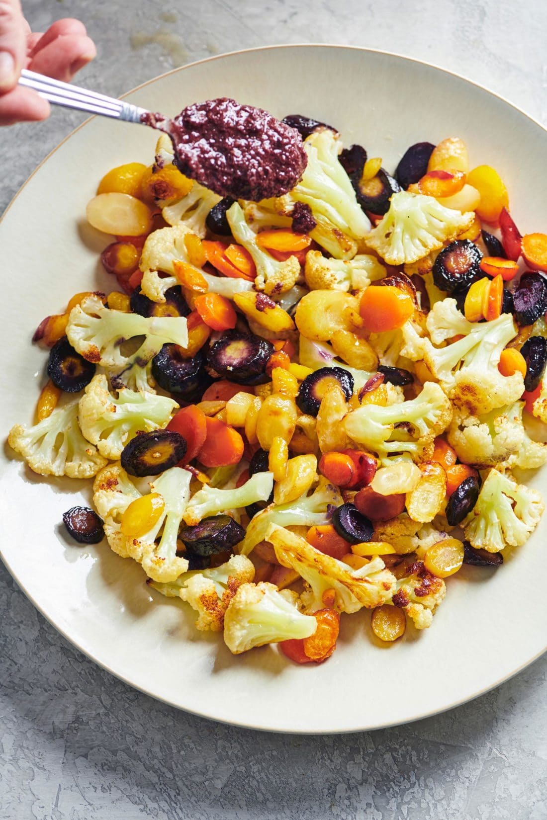 Roasted Cauliflower and Carrots with Olive Drizzle on a large white plate.