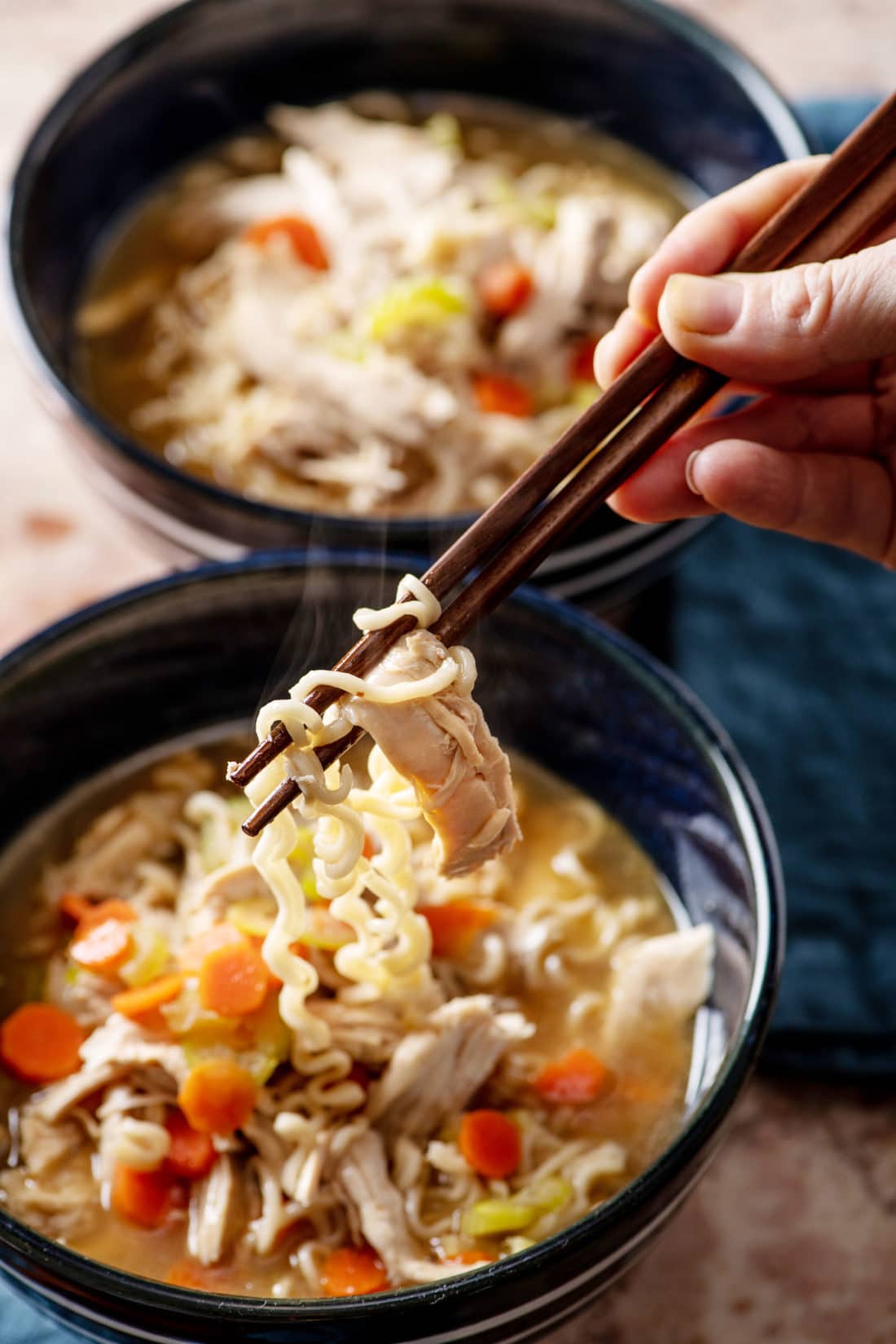 Chopsticks grabbing Chicken Ramen Noodle Soup.