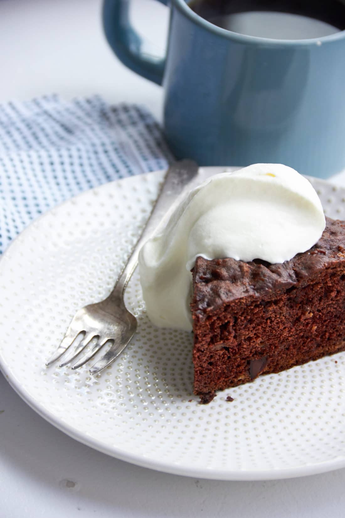 Slice of Chocolate Banana Cake topped with whipped cream.