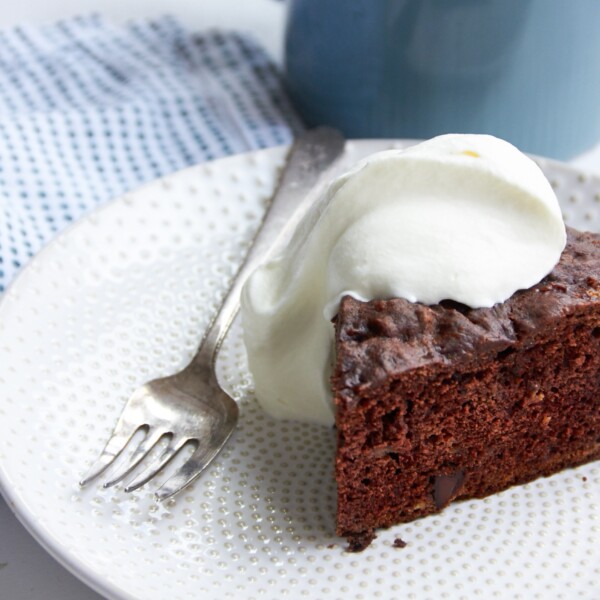 Slice of Chocolate Banana Cake topped with whipped cream.