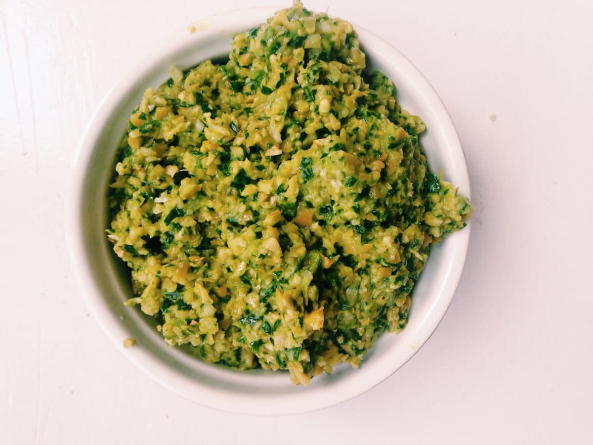 Green Olive and Ramp Tapenade in white bowl.