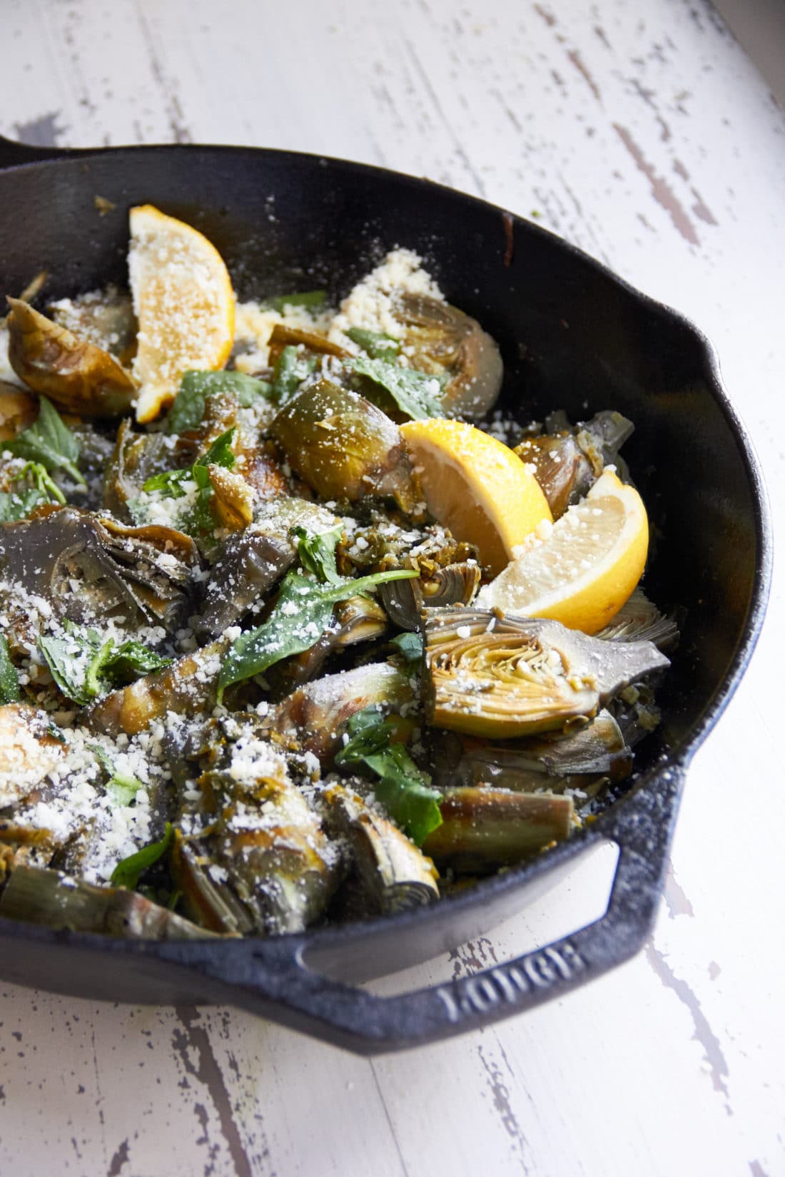 Braised Baby Artichokes with Leeks and Capers topped with parmesan cheese.