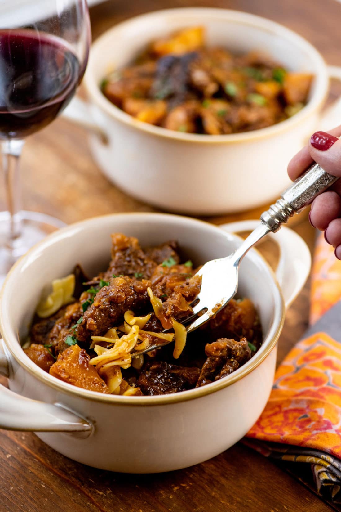 Fork grabbing pieces of Barbecue Beer Beef Stew from a bowl.