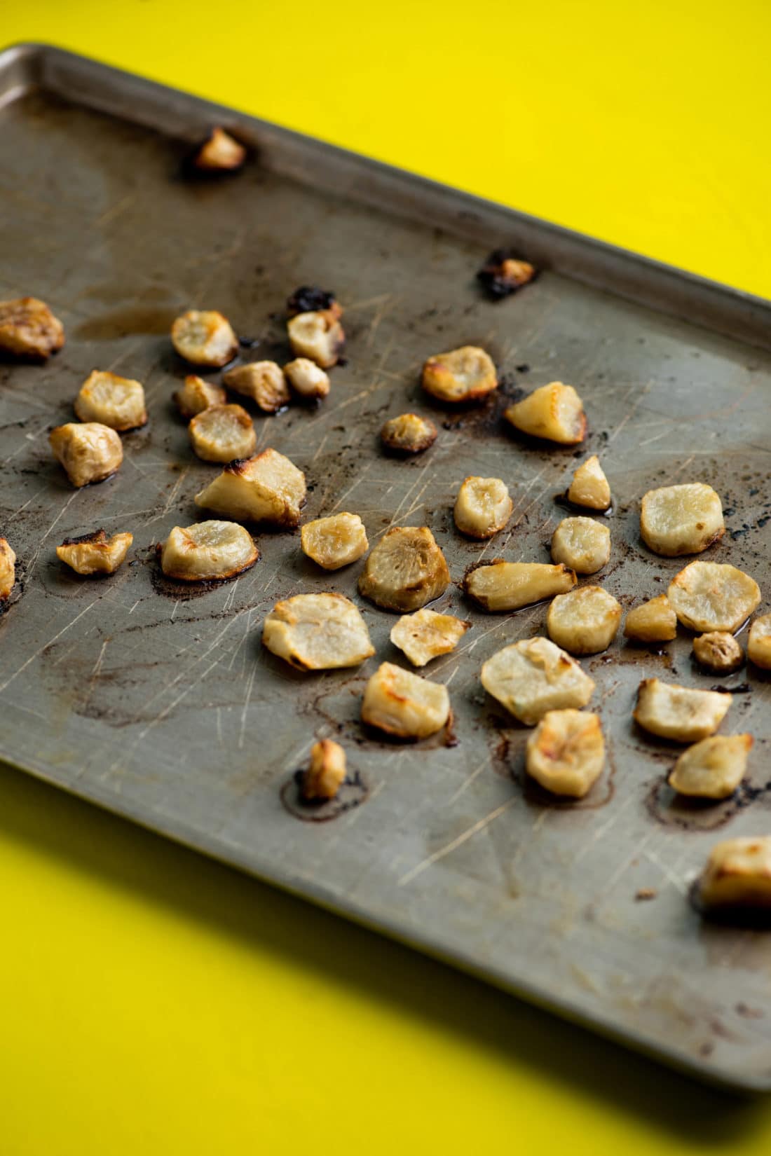 Sliced Roasted Jerusalem Artichokes on a baking sheet.