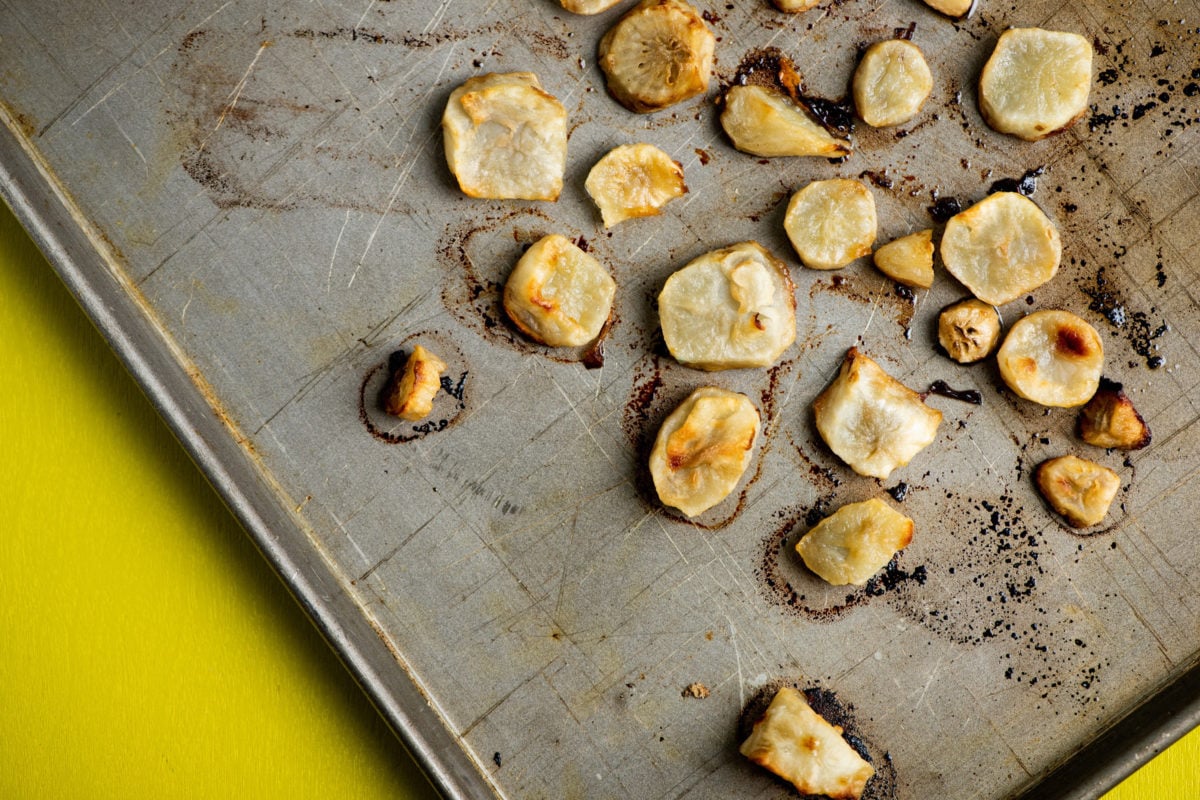 Baking sheet of sliced Roasted Jerusalem Artichokes.