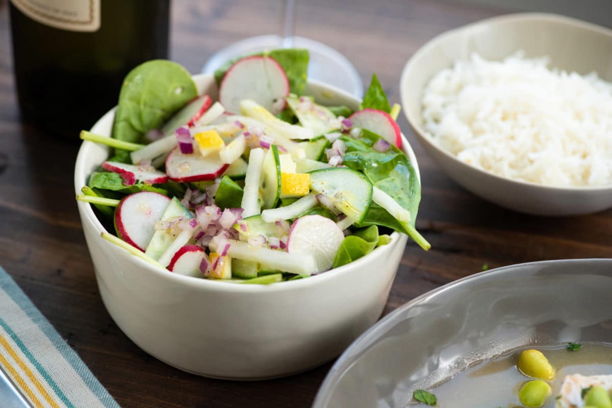 Spinach, Radish, and Kohlrabi Salad with Preserved Lemons in white bowl.