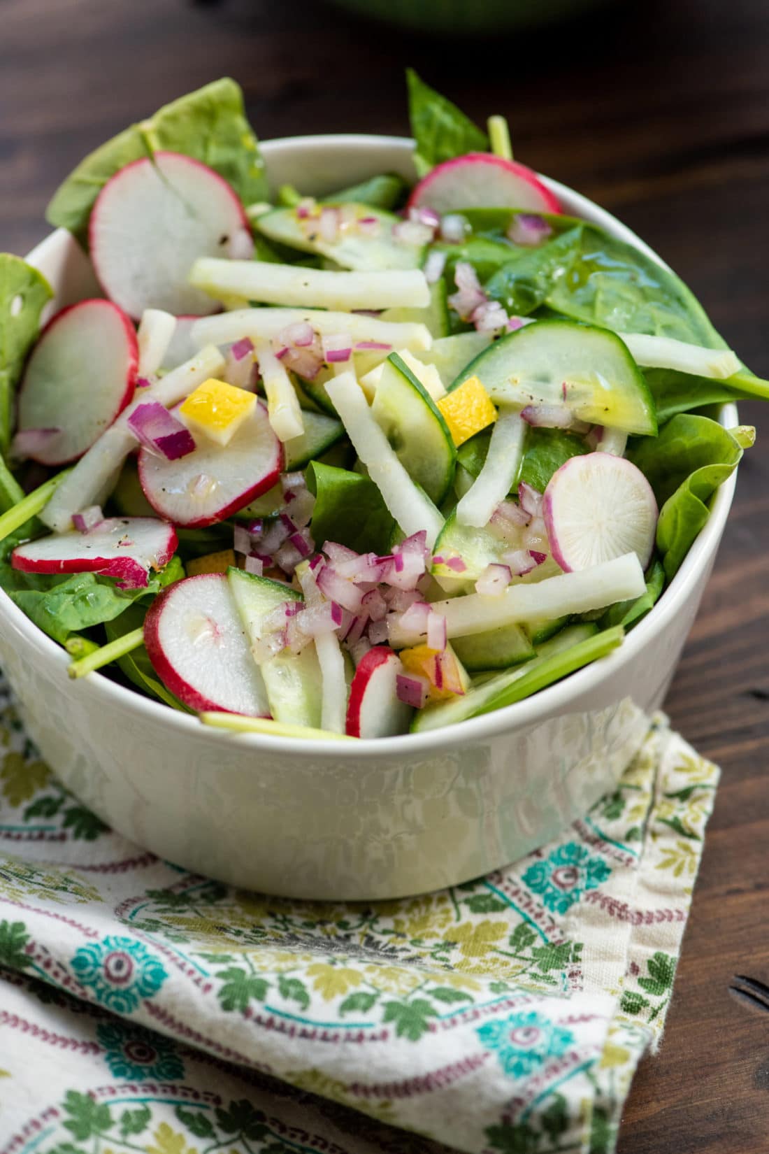 Spinach, Radish, and Kohlrabi Salad with Preserved Lemons in a white bowl.