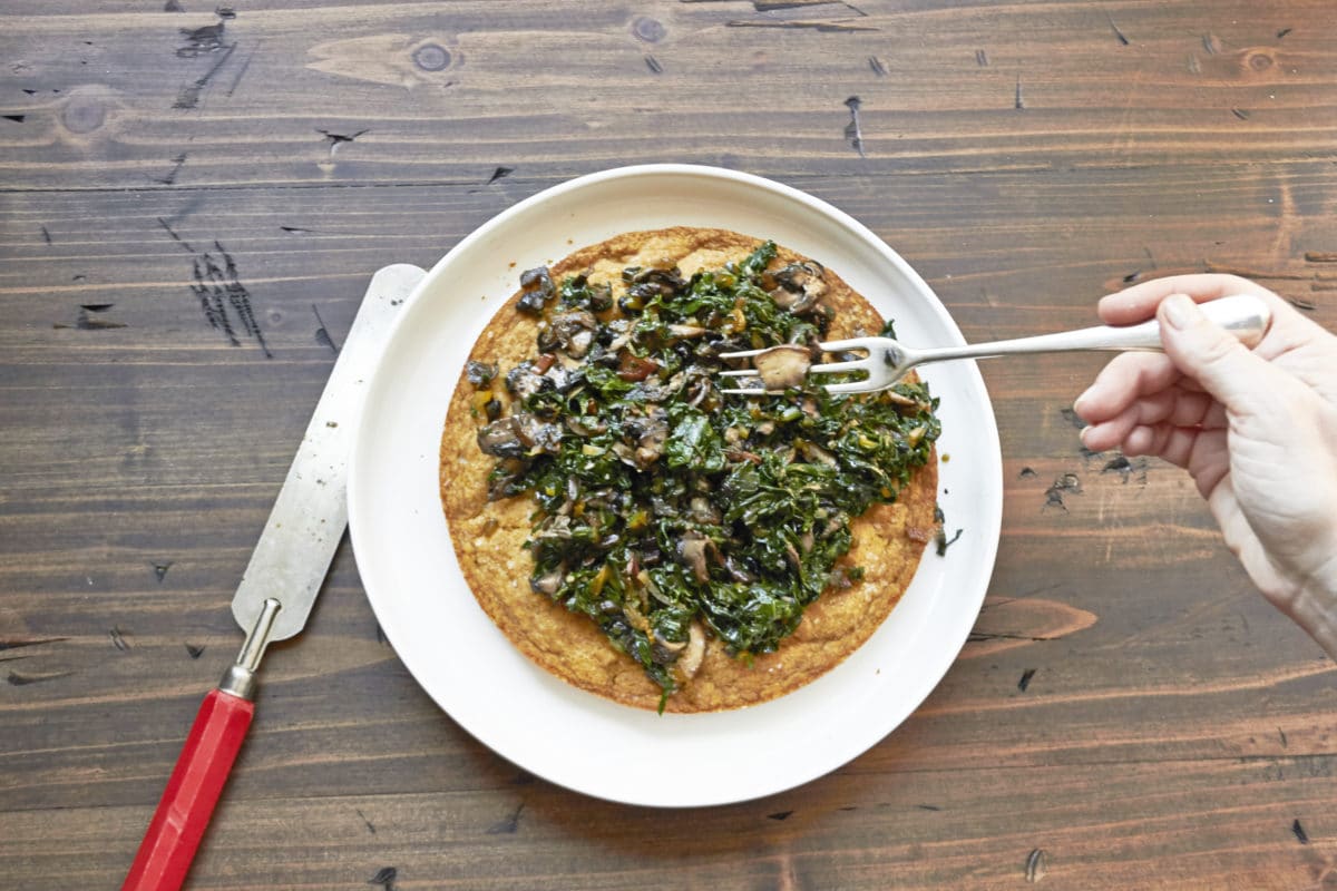 Fork topping a Big Biscuit with Swiss Chard and Mushrooms.