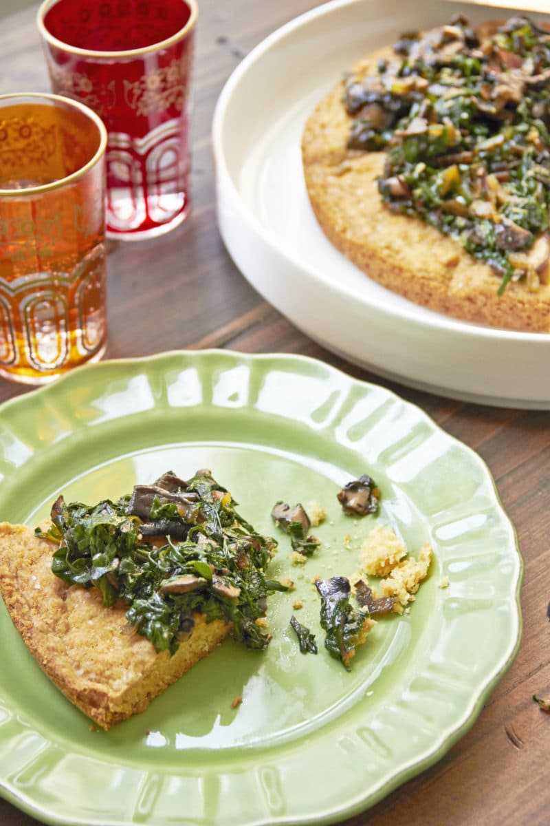 Slice of Biscuit with Swiss Chard and Mushrooms on a green plate.