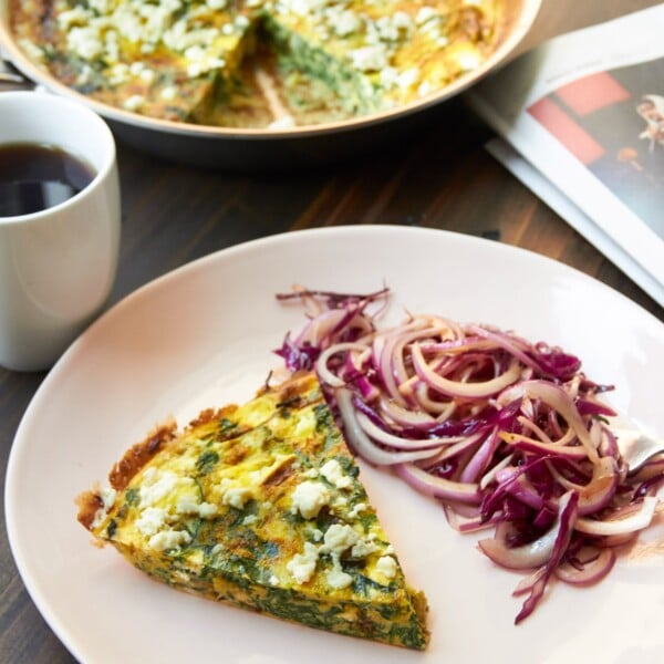 Slice of Swiss Chard Frittata on a plate with onions.