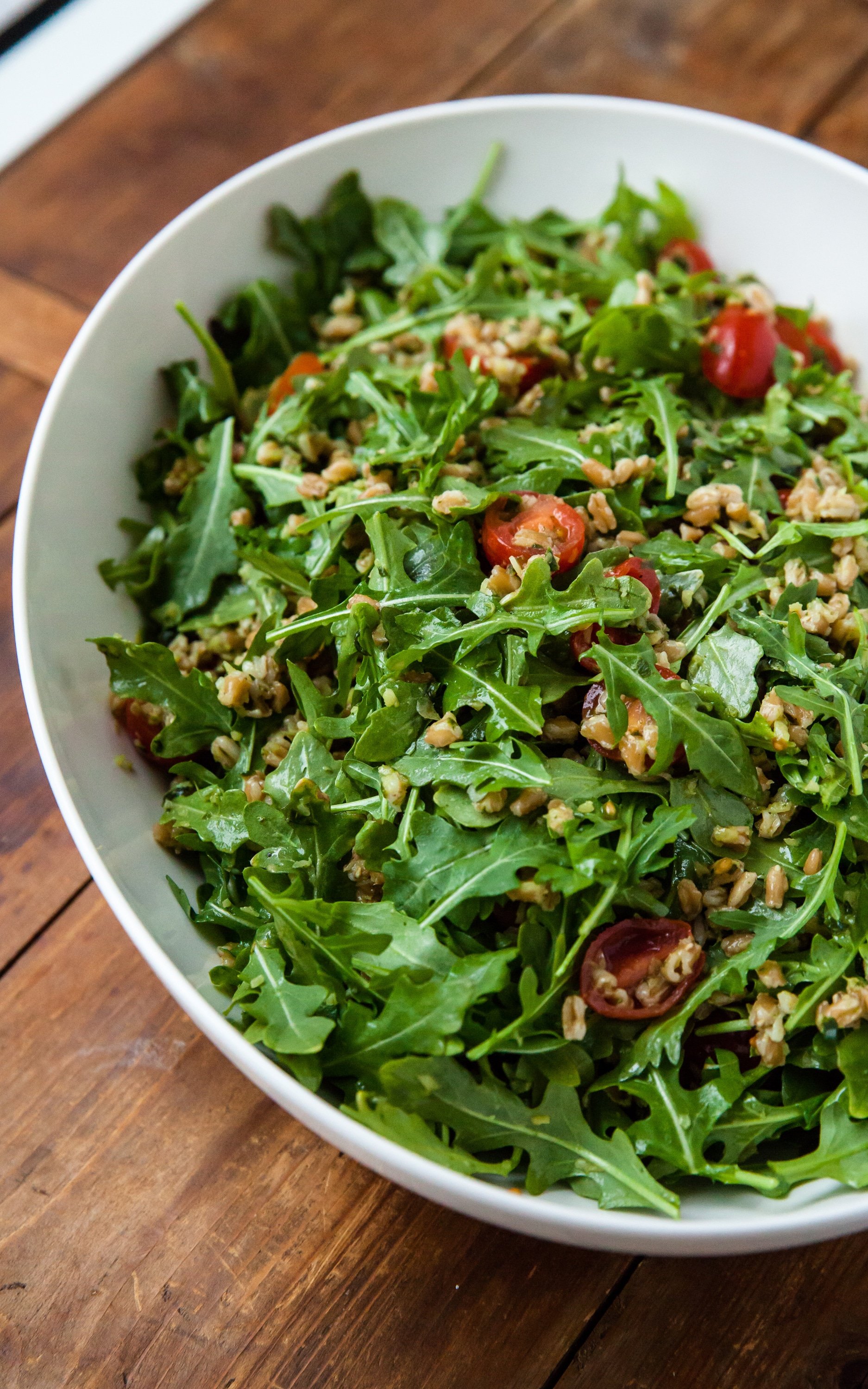 Farro and Arugula Salad with Orange Herb Vinaigrette in a white bowl.