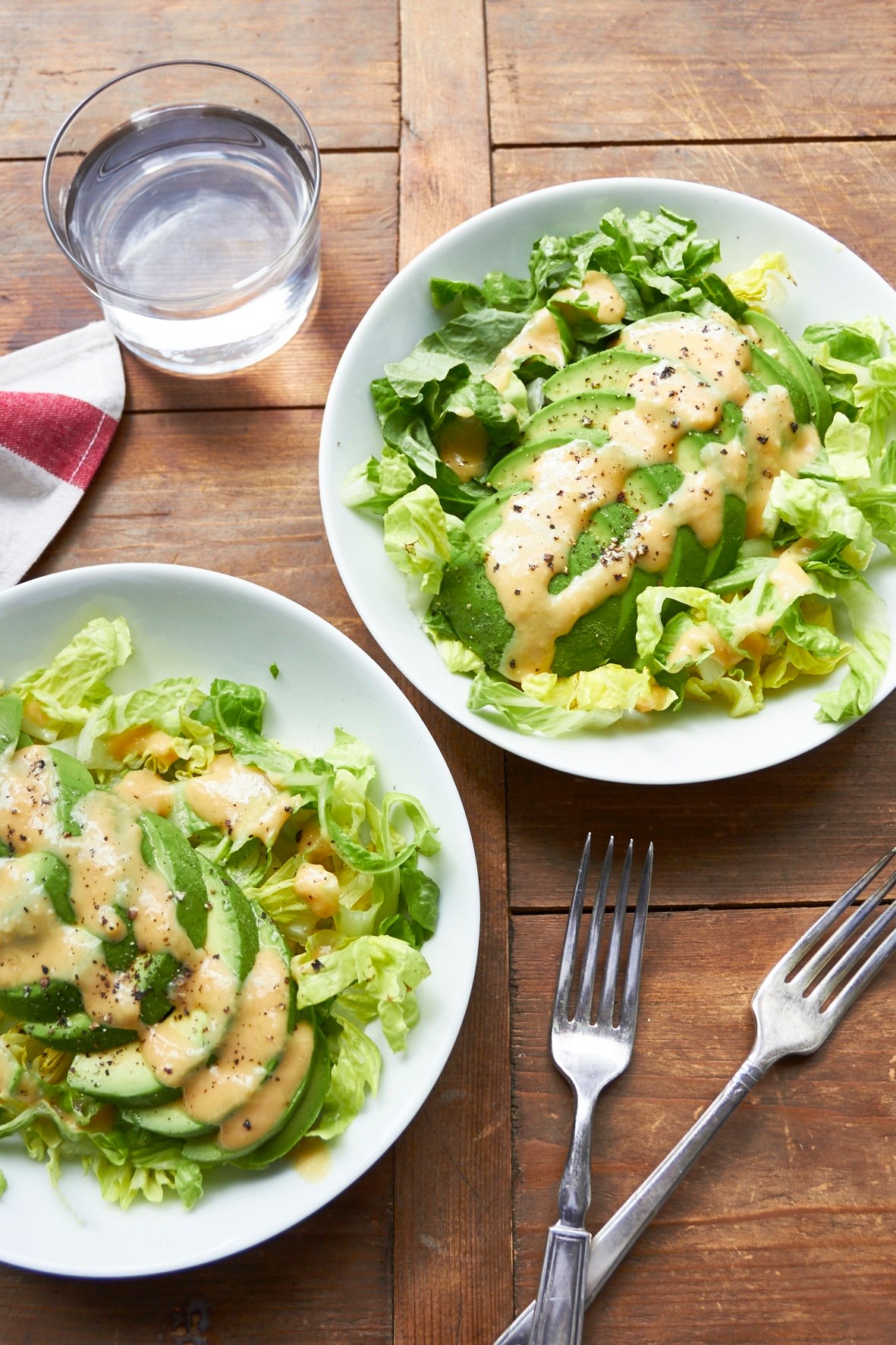 Two plates of avocado salad with creamy miso dressing.