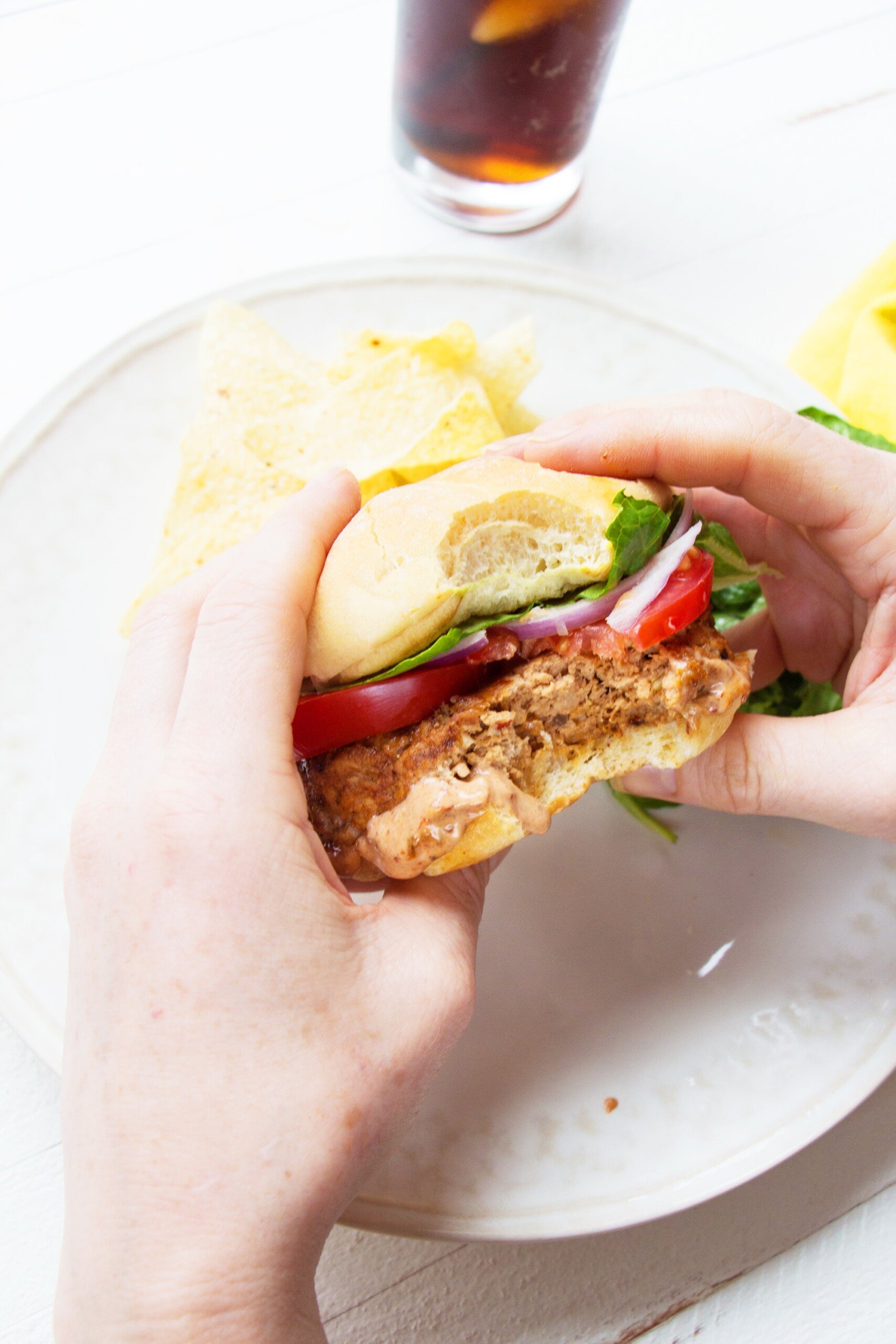 Person holding a Chipotle Barbecue Turkey Burger missing a bite.
