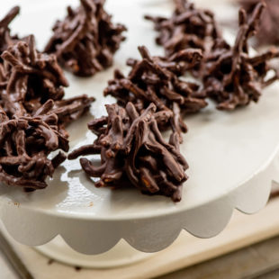 White serving dish of Chocolate, Peanut and Pretzel No-Bake Haystack Cookies.