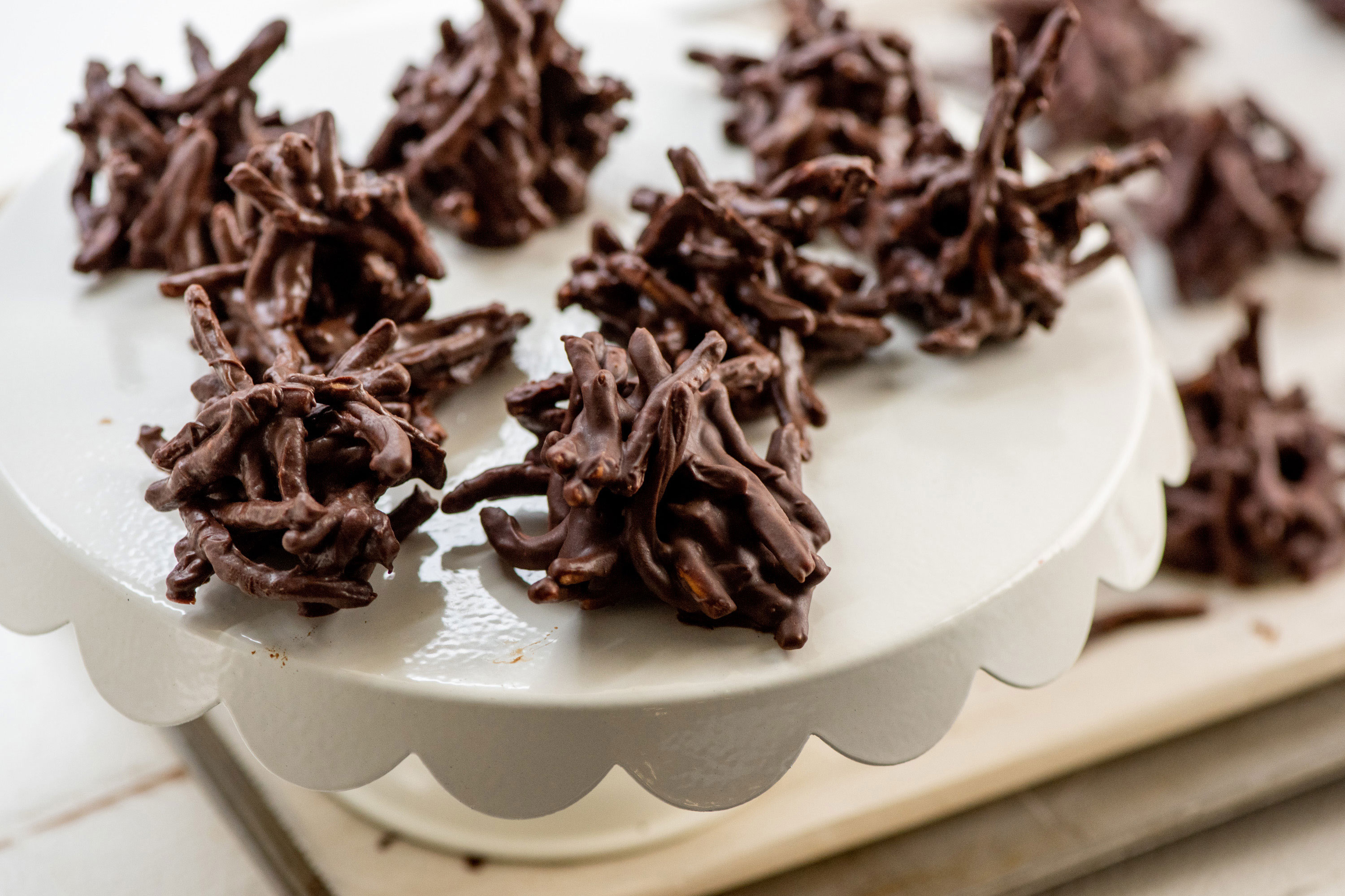 White serving dish of Chocolate, Peanut and Pretzel No-Bake Haystack Cookies.