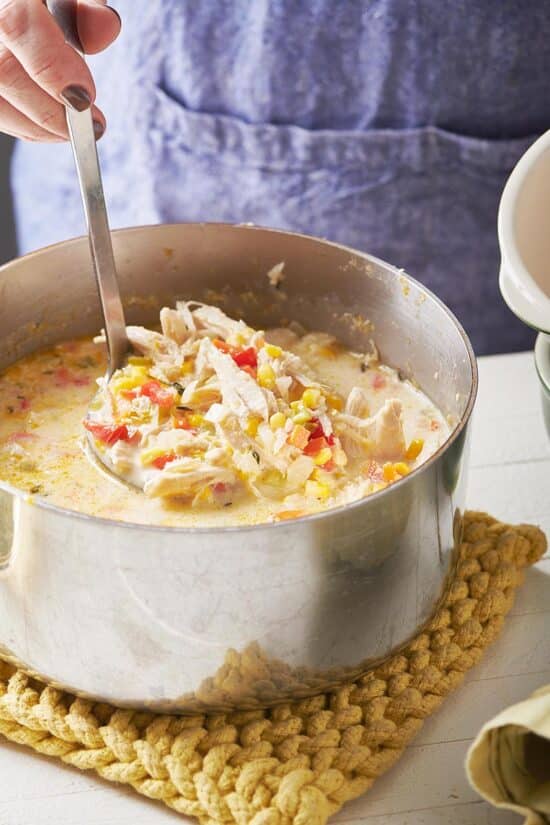 Ladle scooping Chicken Corn Chowder from a pot.