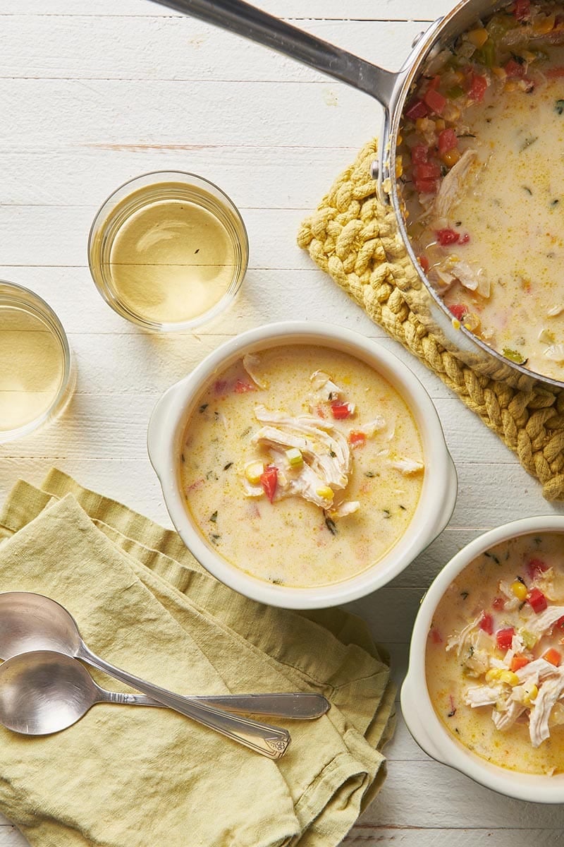 Two bowls and a pot of Chicken Corn Chowder.
