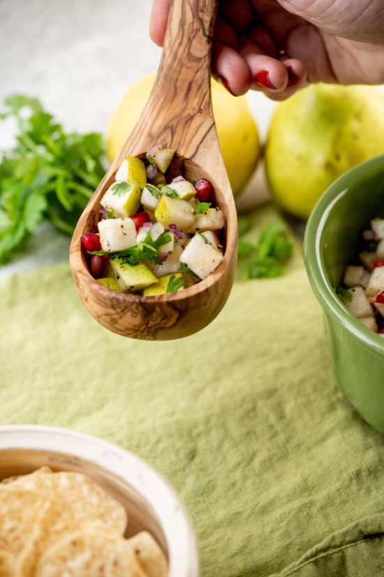 Wooden spoon full of Spicy Pear and Cilantro Salsa.