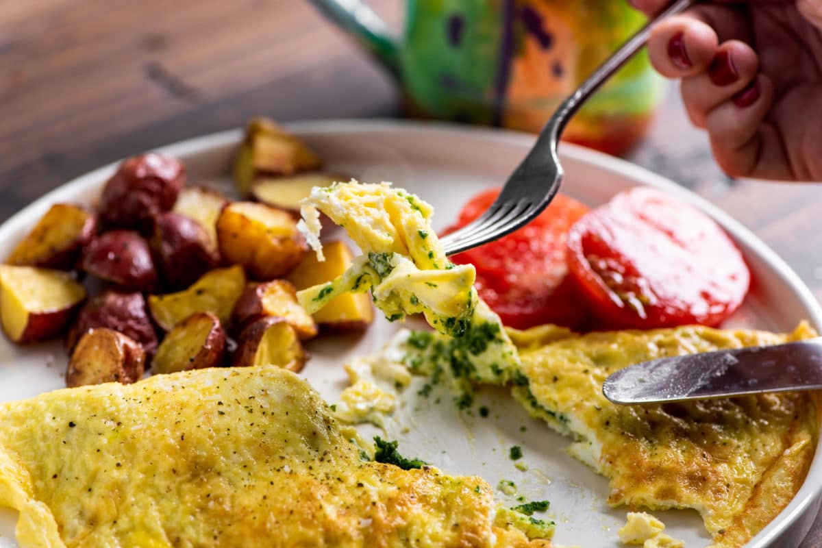 Fork grabbing a piece of Kale Pesto and Goat Cheese Omelet.