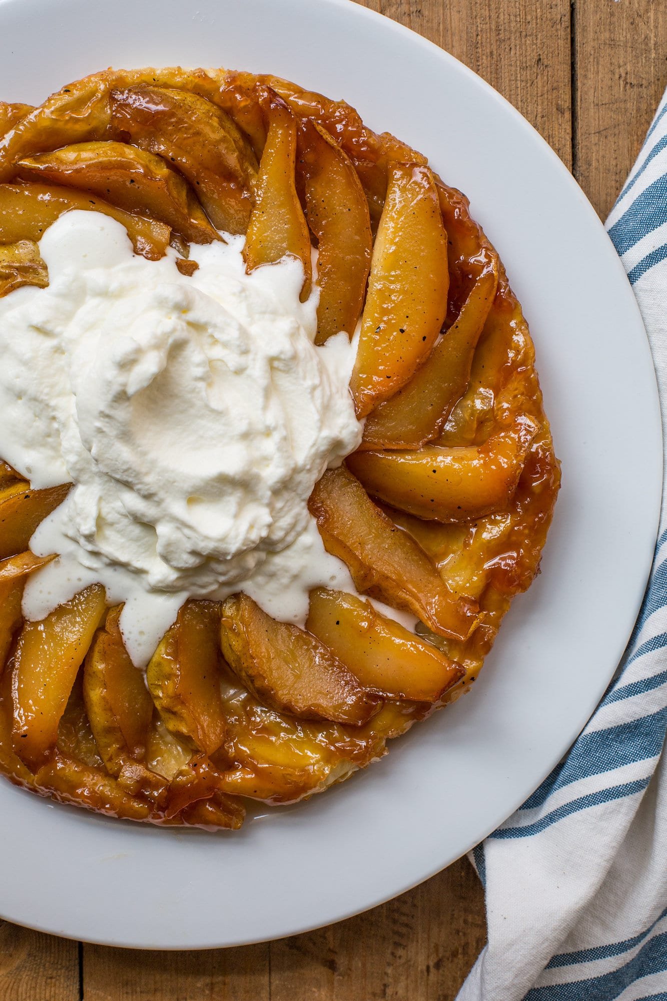 Pear Tart Tatin topped with sweetened whipped cream.