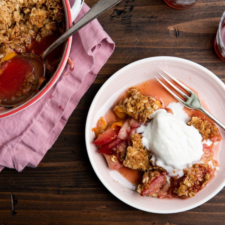 Plum and Nectarine Crisp in a Dutch oven and on a plate.
