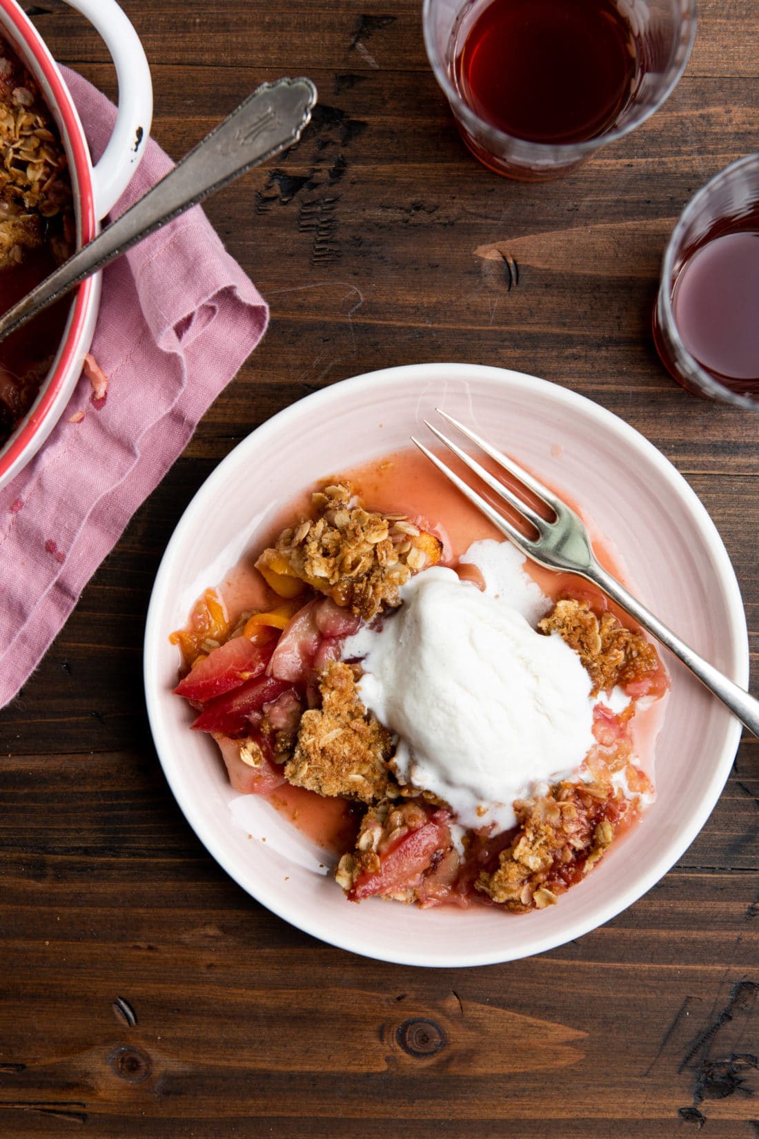 Plate of Plum and Nectarine Crisp topped with ice cream.