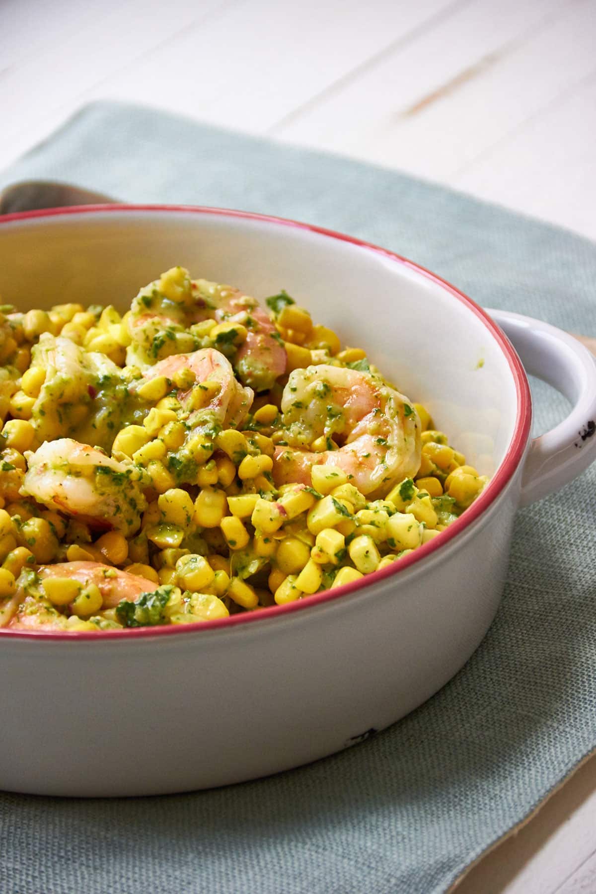 Shrimp and Corn Salad with Basil Dressing in a red-rimmed bowl.