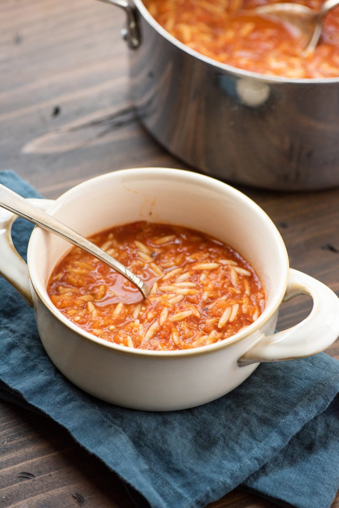 Spoon in a bowl of Tomato, Orzo and Dill Soup.