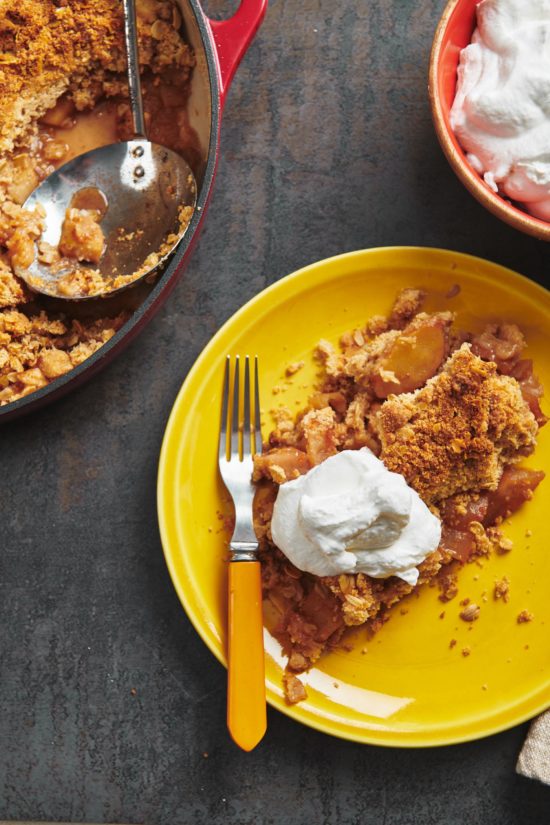 Apple crisp with streusel on yellow plate with fork