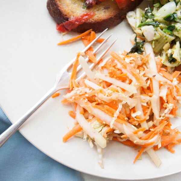 Carrot, Cabbage and Kohlrabi Slaw on plate with other dishes.