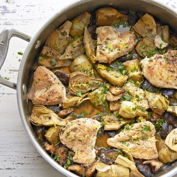 Braised Chicken, Mushrooms and Baby Artichokes in a skillet.